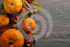 Thanksgiving background. Autumn composition with ripe pumpkins, autumnal fruits and dry leaves on dark wooden table. Flat lay, top