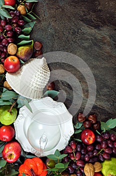 Thanksgiving background with autumn fall leaves, fruit, nuts and tableware.