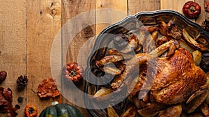 The Thanksgiving banner with traditional turkey isolated on wooden background with dry leaves and pumpkins. The thanksgiving dish