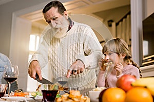 Thanksgiving Celebration Tradition Family Dinner Concept. family having holiday dinner and cutting turkey. Old handsome