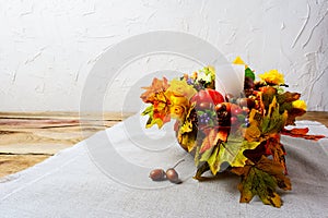 Thanksgiving centerpiece with white candle and silk fall leaves