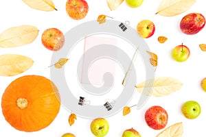 Thanksgiving day. Autumn composition of fall leaves, apple fruits and pumpkin with pink diary, pen and clips on white background.