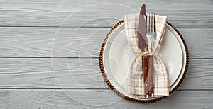 Thanksgiving day concept. Top view photo of table setting plate knife fork and napkin on isolated grey wooden table background