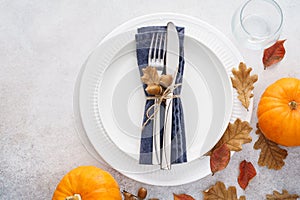 Thanksgiving Day table setting with leaves and pumpkins