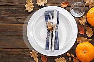 Thanksgiving Day table setting with leaves and pumpkins