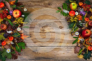 Thanksgiving decor with pumpkin, apples and green leaves on wood