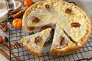 Thanksgiving dessert. Fall traditional pie pumpkin with crumble and pecan on a gray stone background