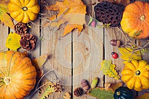 Thanksgiving dinner background. Autumn pumpkin and fall leaves on wooden table.