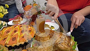 Thanksgiving Dinner. A happy multiethnic family with children together at a festive table. Mother cuts turkey