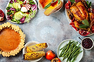 Thanksgiving dinner table with roasted whole chicken or turkey, green beans, mashed potatoes, cranberry sauce, grilled vegetables