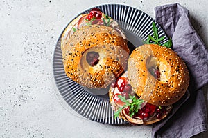 Thanksgiving food concept. Bagel sandwich with turkey and cranberry sauce on a gray plate