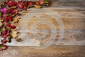 Thanksgiving greeting with berries, acorn, fall leaves on woode