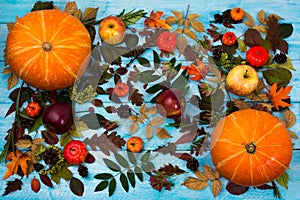 Thanksgiving greeting with fall leaves and pumpkin on blue background