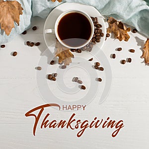 Thanksgiving greetings. Aromatic drink, black coffee and spices, dried leaves on a wooden background, top view. Kaligraphic