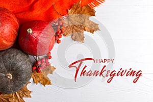 Thanksgiving greetings. Pumpkins, dry leaves on a white background, top view. Kaligraphic capital inscription