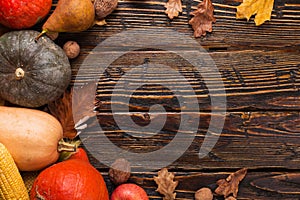 Thanksgiving greetings. Pumpkins, vegetables, nuts, dry leaves on a wooden background, top view. Kaligraphic capital inscription