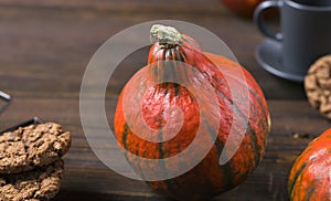 Thanksgiving, Halloween. Hot drink for breakfast. Bright orange pumpkin on a wooden background. Warm autumn harvest concept.