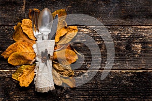 Thanksgiving Meal Setting. Seasonal table setting. Thanksgiving autumn place setting with cutlery and colorful fall fall leaves.