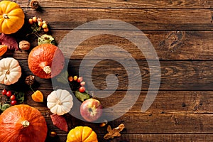 Thanksgiving still life with orange pumpkins, acorns, fall leaves, berries on rustic wooden background. Flat lay, top view, copy