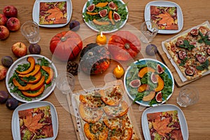 Thanksgiving table served, decorated with bright autumn leaves