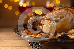 Thanksgiving turkey with a baked potatoes isolated on wooden background with bright yellow lamps and two wineglasses with red wine