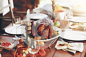 Thanksgiving, turkey and food with a roast meal on a dinner table for a celebration event or tradition. Christmas