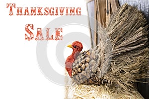 Thanksgiving turkey made out of pinecone and burlap and straw at side of white background - selective focus - Thanksgiving sale
