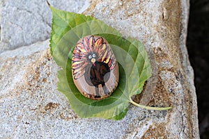 Thanksgiving turkey painted rock on a Fall leaf