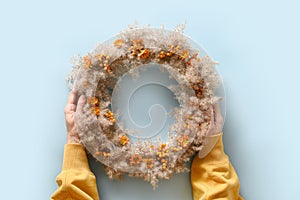 Thanksgiving wreath with orange flowers and dry natural materials isolated over white bakground. Top view.