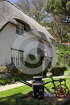 Thatched cottage with decorated milk churn