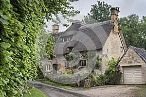 Thatched cottage in the village of Stanton, Cotswolds district of Gloucestershire.  It`s built almost completely of Cotswold stone