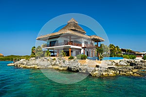 Thatched house on the rocks by the sea