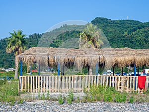 Thatched roof restaurant. Vacation at the resort. Nice secluded place. Roof of dried leaves. Rest on the sea