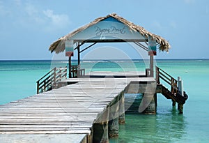 Thatched roofed jetty of Pigeon Point Beach in the Caribean sea on Tobago