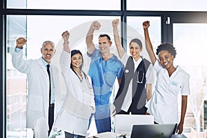 Thats another life saved. Cropped portrait of a group of medical professionals standing with their hands raised in the