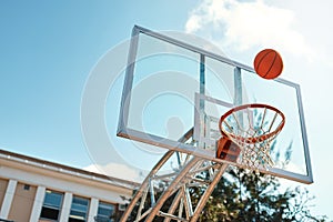 Thats going to be an airball shot. Still life shot of a basketball landing into a net on a sports court.