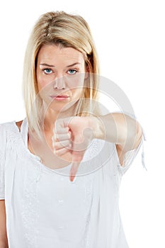 Thats a no from me. Studio portrait of a young woman giving thumbs down against a white background.