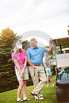 Thats perfect. an affectionate mature couple spending a day on the golf course.