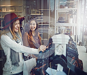 Thats so your style. two best friends out shopping in a clothing store.