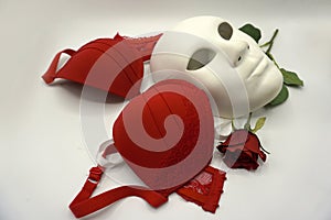 Theater or romance concept. Closeup of white classical theatrical mask and red underware as a symbol of sexual freedom
