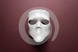 Theatre concept with the white masks on trendy vinous bordeaux, burgundy background. Anonimous, Incognito, Conspiracy