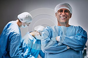 Theatre, portrait and man doctor with arms crossed for hospital teamwork, leadership and medical surgery. Happy surgeon