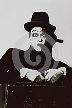 Theatrical actor with dark makeup on her face with a suitcase