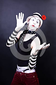 Theatrical mime in white hat with red flower