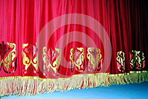 Theatrical red velvet curtain with gold pattern background