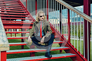 A theatrically dressed pseudo soldier or pirate with a blindfold in one eye sits on the stairs.