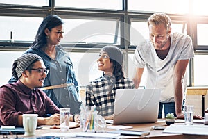 Their idea bounce off perfectly from each other. a group of businesspeople working together on a laptop in an office.