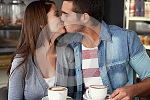 Their love knows no boundries. a young couple kissing in a cafe.