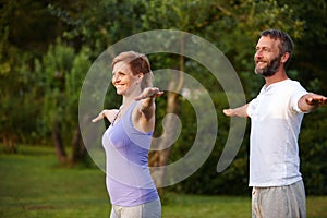 Their secret is daily yoga. a happy mature couple doing yoga in nature.