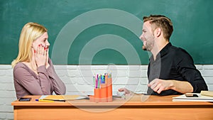 Their troubles are all over. High school education. Teacher and schoolmaster sitting at desk. Handsome man and sexy